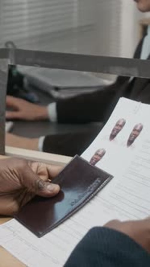 Vertical of Female Consulate Officer Accepting Visa Application from Black Man