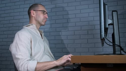 Frustrated Man Working Late at a Computer