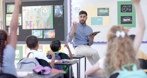 Young Asian man teaches in a vibrant classroom at school