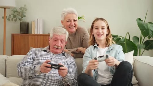 Grandparents and Teen Playing Video Game Together at Home