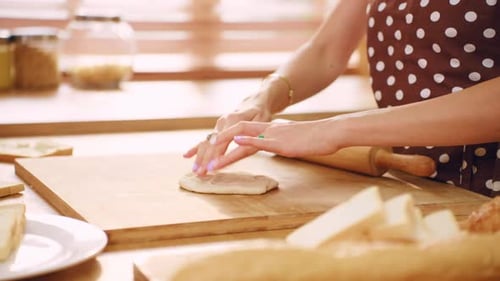 Close up of woman kneaded yeast dough with hand in kitchen at home.