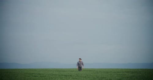 Farmer Walking In Field Against Sky