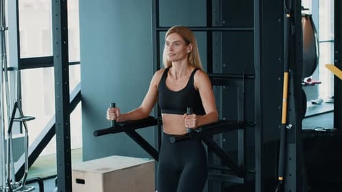 Woman Using Strength Training Equipment at a Modern Gym During a Workout Session