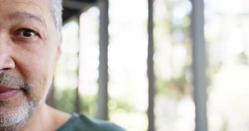 Portrait of happy biracial senior man in sunny outdoors, copy space