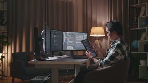 Programmeur regardant la base de données sur une tablette tout en créant un ingénieur logiciel développant une Appli, un programme