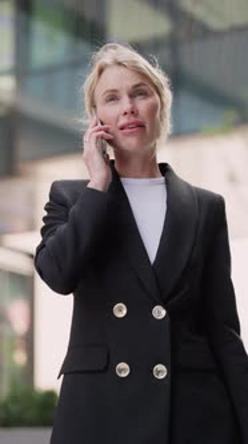 Portrait of Friendly Blonde Lady Entrepreneur Talks on Mobile Phone in Downtown