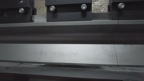 Man Works Metal Bending Machine in Factory