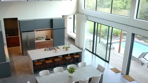 Modern kitchen and dining area with large table and stylish chairs, copy space
