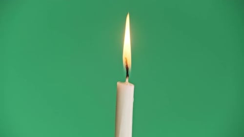 One Candle Burns on a Green Background Chroma Key