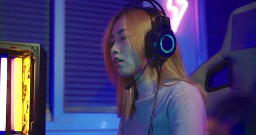 Enthusiastic Woman Playing Video Game in Neon Lit Room