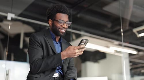 Smiling Businessman Using Smartphone in Modern Office Happy Entrepreneur Browsing Internet on Mobile