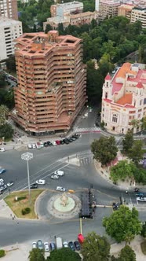 Aerial drone view of cars moving on the streets between the buildings in Valencia, Spain in daylight