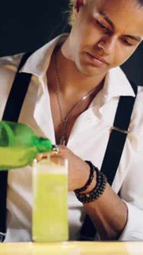 Young Adult Bartender Pouring Drink into Glass