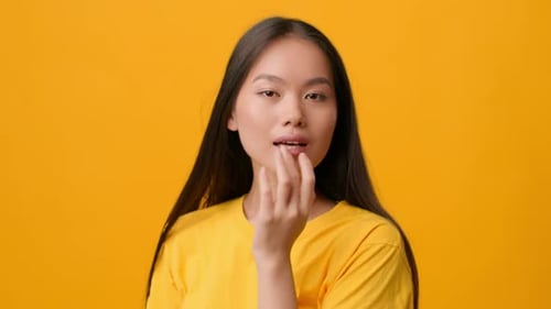 Young Woman Poses in Front of Yellow Background
