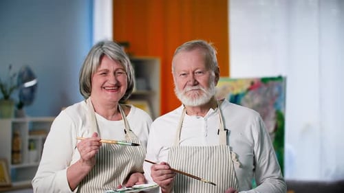 Smiling Senior Couple Ready to Paint Together