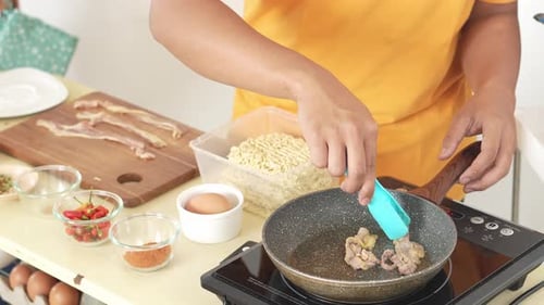 Cooking meat in a frying pan indoors