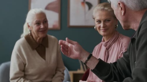 Senior Friends Chatting Indoors in Living Room Setting
