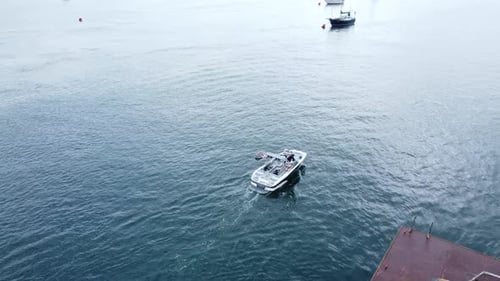Following speed boat aerial above view navigating Conwy marina metal jetty