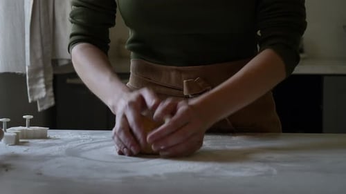 Woman Kneading Dough in Bright Kitchen