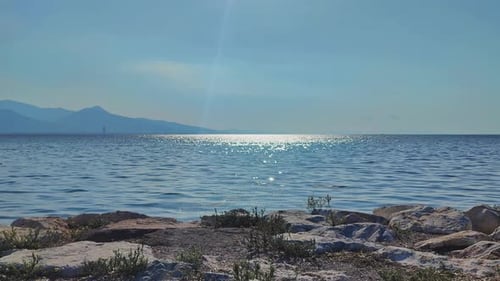 Rocky Shore And Sun Glows In The Ocean