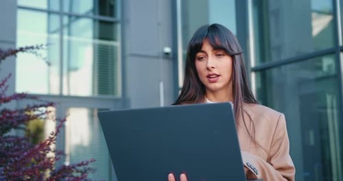 Close Up of Business Woman Talking on Video Call Using Laptop Outdoors Near Office Building Online
