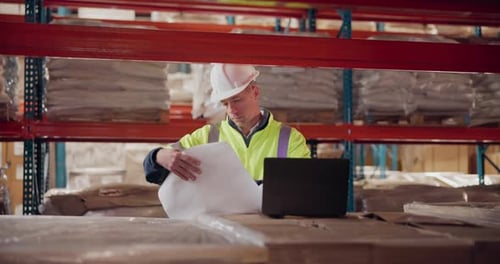 Architect, man and laptop with floor plan at warehouse planning a building design