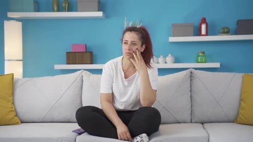 Woman Thinking on Couch in Bright Living Room