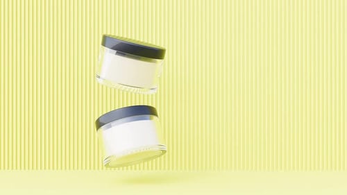 Clear Cream Glass Jar Floating Skin Care Vessels on Yellow Bg Able to Loop Endless