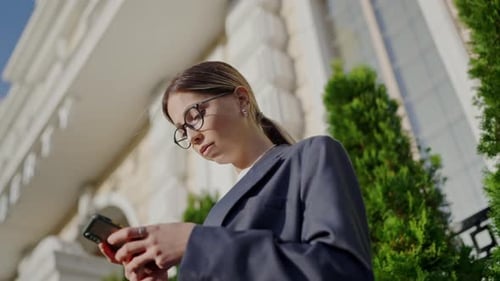 Young Woman Uses Smartphone in an Urban Setting