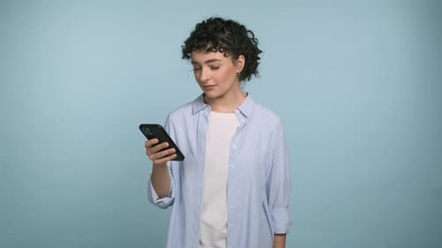 Young Woman with Phone Smiling in Studio