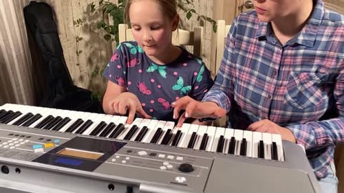Child Learning Piano with Teacher at Home