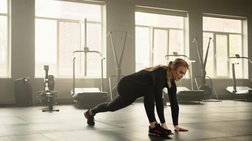 Young Pretty Fit Blonde Performing Stretching Exercises in Fullyequipped Gym