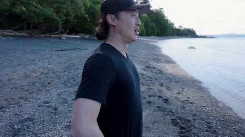 Tired Male Runner with Smart Watch Checking Pulse on Ocean Beach 4044 Years
