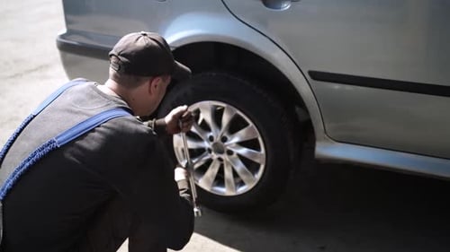 Car wheel service. Mechanic changing tires and rims, balancing the wheels