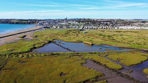 Aerial dolly towards Tramore, Ireland with morning blue sky