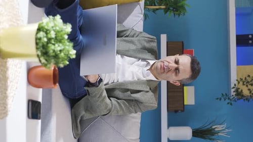 Man Working on Laptop While Sitting on Sofa