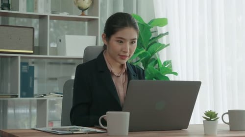 Enthusiastic businesswoman working and typing laptop in the office.