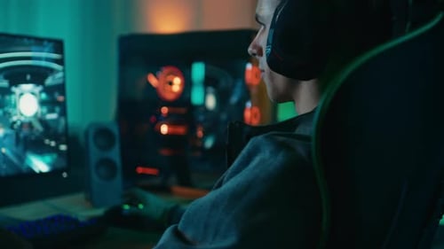 Focused young man gaming on computer at home