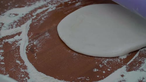 Closeup Shot of Male Baker Hands Rolls Dough in Flour on Table with a Rolling Pin