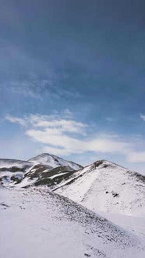 Vertical video of Aerial view drone flying over beautiful white snowy mountains