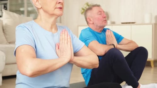 Mature Couple Meditating Together at Home