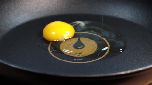 Egg Being Fried in a Black Pan