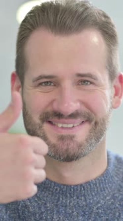 Man in Gray Sweater Gives a Thumbs Up