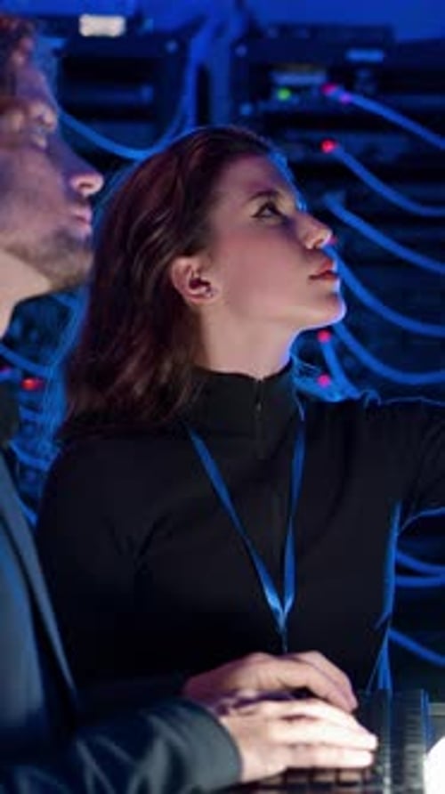 Young Adults Working in Server Room at Night