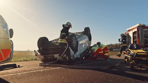 Emergency Responders Assist Overturned Car Crash on Road