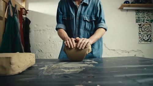 Artist Kneading Clay at Pottery Studio