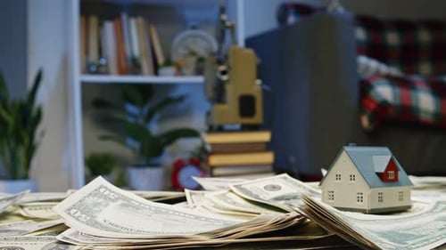 Miniature House on Pile of Dollar Bills