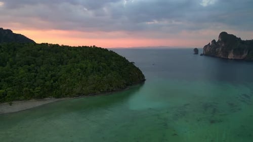 Sunset cloudy sky tropical island, boats in turquoise sea. Breathtaking aerial view flight drone