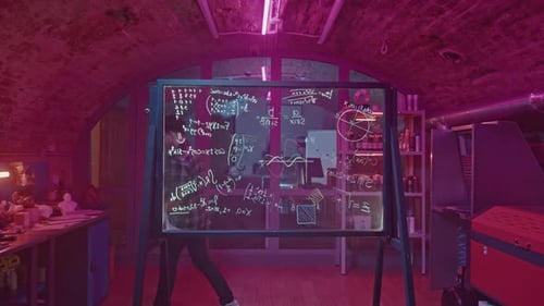 Young Adult Writes Equations on Whiteboard in Lab