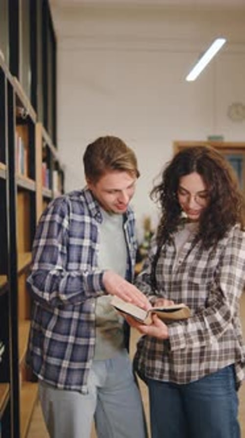 Young Couple Enjoys Reading Together in a Cozy Library Setting During a Quiet Afternoonvertical